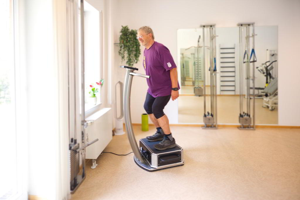 Ein Patient steht freihändig auf einem Galileo-Gerät