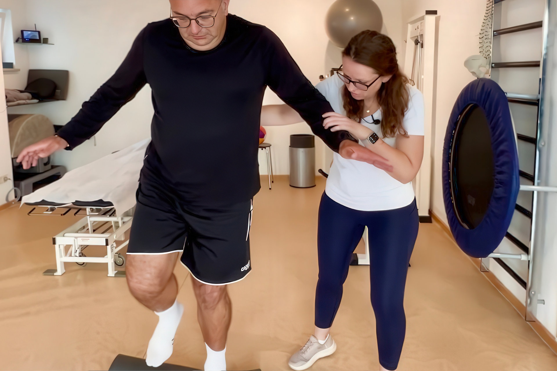 Die Therapeutin gibt bei der Übung Hilfestellung